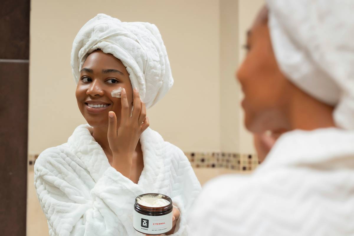 Woman applying retinol cream anti aging moisturizer at night with calm skin